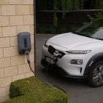 black car parked beside brown brick wall